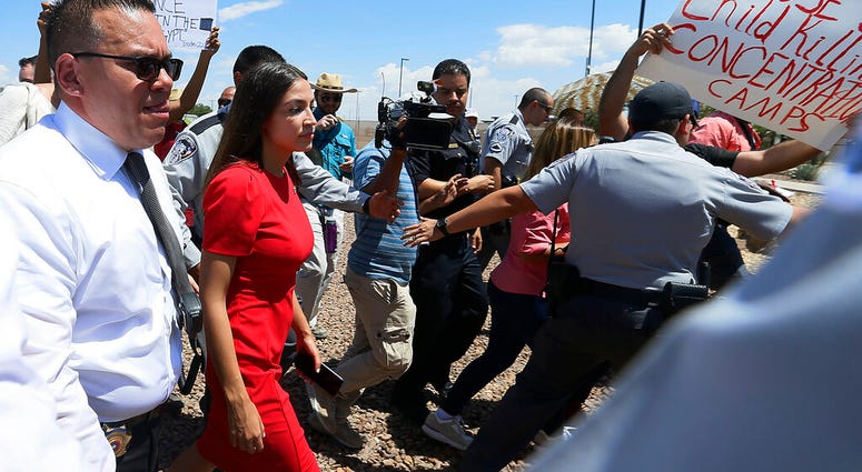 U.S. Rep. Alexandria Ocasio-Cortez, D-New York, is escorted back to her vehicle after she speaks at the Border Patrol station in Clint, Texas, about what she saw at area border facilities on July 1, 2019. (Briana Sanchez/El Paso Times via AP)