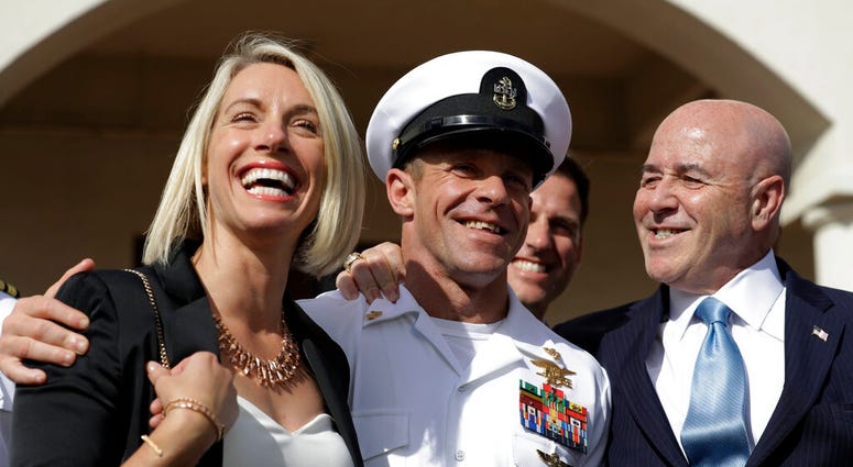 Navy Special Operations Chief Edward Gallagher, center, walks with his wife, Andrea Gallagher, left, and advisor, Bernard Kerik as they leave a military court on Naval Base San Diego, Tuesday, July 2, 2019. (AP Photo/Gregory Bull)