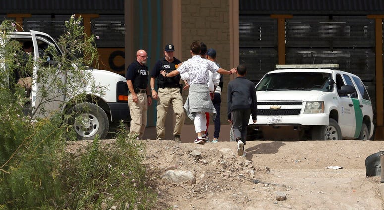In this July 4, 2019 file photo, a group of asylum seekers cross the border between El Paso, Texas, and Juarez, Chihuahua, Mexico, Thursday, July 4, 2019. (Mark Lambie/The El Paso Times via AP)