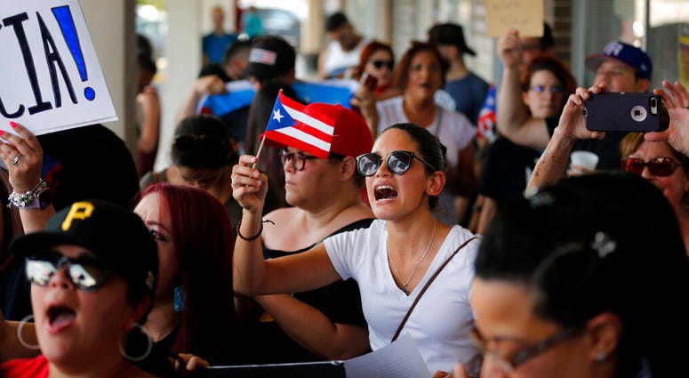 About 200-300 people from the North Texas (Dallas-Fort Worth area) Puerto Rican community gather to protest Gov. Ricardo Rossello outside the Adobo Puerto Rican Cafe in Irving, Texas. (Tom Fox/The Dallas Morning News via AP) About 200-300 people from the North Texas (Dallas-Fort Worth area) Puerto Rican community gather to protest Gov. Ricardo Rossello outside the Adobo Puerto Rican Cafe in Irving, Texas. (Tom Fox/The Dallas Morning News via AP)