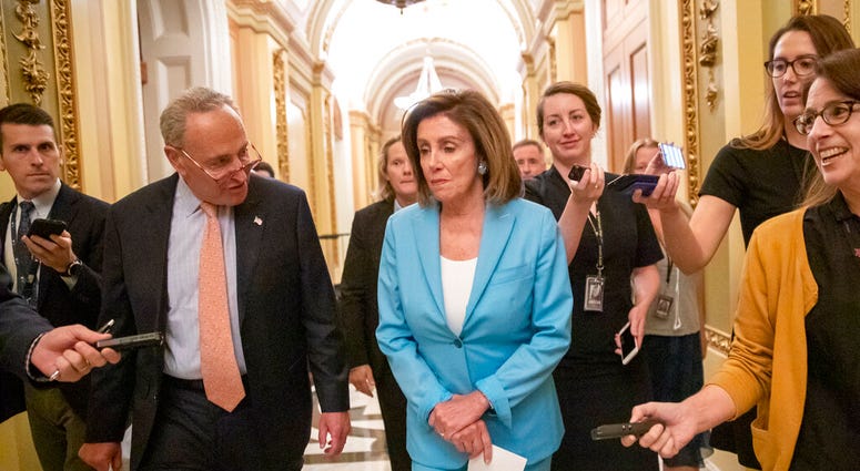 Senate Minority Leader Chuck Schumer, D-N.Y., left, joins Speaker of the House Nancy Pelosi, D-Calif., on the way to sign the budget package just passed in the Senate. (AP Photo/J. Scott Applewhite)