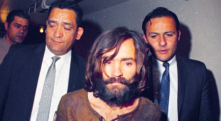 FILE - In this 1969 file photo, Charles Manson is escorted to his arraignment on conspiracy-murder charges in connection with the Sharon Tate murder case in Los Angeles. Fifty years ago Charles Manson dispatched a group of disaffected young hippie followe