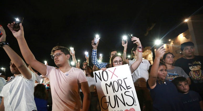 People gather in Juarez, Mexico, Saturday, Aug. 3, 2019, in a vigil for the 3 Mexican nationals who were killed in an El Paso shopping-complex shooting. (AP Photo/Christian Chavez)