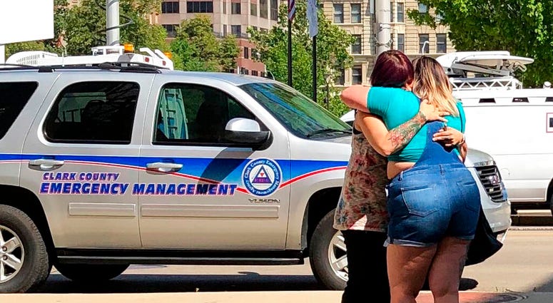 Residents comfort each other as they await word on whether they know any of the victims of a mass shooting on Sunday, Aug. 4, 2019, in Dayton, Ohio. (AP Photo/Julie Carr Smyth)