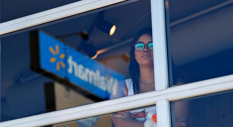 A restaurant employee looks at the scene of a mass shooting at a shopping complex Sunday, Aug. 4, 2019, in El Paso, Texas. (AP Photo/John Locher)