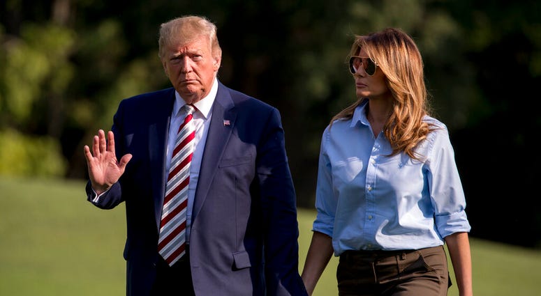 President Donald Trump waves to members of the media as he and first lady Melania Trump walk across the South Lawn of the White House in Washington, Sunday, Aug. 4, 2019, as they return from Bedminster, N.J. (AP Photo/Andrew Harnik)