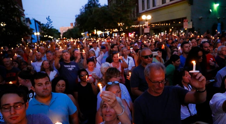 Mourners gather for a vigil at the scene of a mass shooting, Sunday, Aug. 4, 2019, in Dayton, Ohio. Multiple people in Ohio were killed in the second mass shooting in the U.S. in less than 24 hours. (AP Photo/John Minchillo)