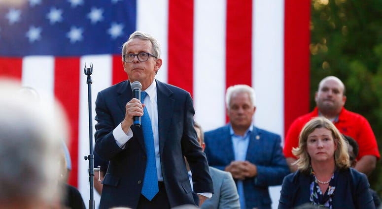 Ohio Gov. Mike DeWine, left, speaks alongside Dayton Mayor Nan Whaley, right, during a vigil at the scene of a mass shooting, Sunday, Aug. 4, 2019, in Dayton, Ohio. (AP Photo/John Minchillo)