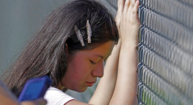This young woman cries while standing outside the Koch Foods Inc., plant as U.S. immigration officials raid the plant in Morton, Miss., Wednesday, Aug. 7, 2019. U.S. immigration officials raided several Mississippi food processing plants on Wednesday and