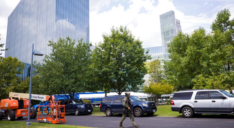 A Fairfax Police tactical officer walks near the building that houses Gannett and USA Today, Wednesday, Aug. 7, 2019, in McLean, Va. (AP Photo/Alex Brandon)