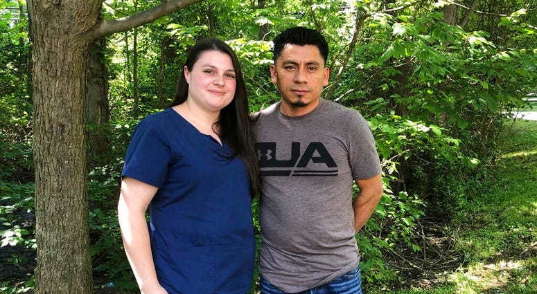 In a photo taken June 21, 2019, Alyse Sanchez and her husband, Elmer Sanchez, pose for The Associated Press in Sandy Spring, Md.