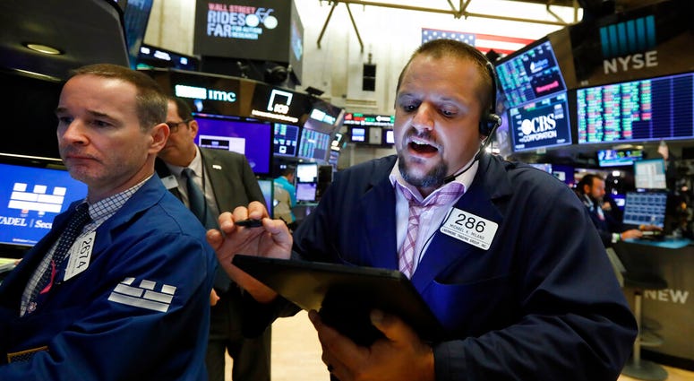 FILE - In this Aug. 19, 2019, file photo specialist Stephen Naughton, left, and trader Michael Milano work on the floor of the New York Stock Exchange. Stocks are opening slightly lower on Wall Street on Tuesday, Aug. 20, as major U.S. indexes give back a