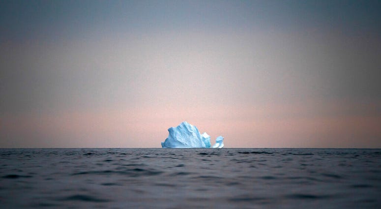 FILE - In this Aug. 15, 2019, file photo, a large Iceberg floats away as the sun sets near Kulusuk, Greenland. As warmer temperatures cause the ice to retreat the Arctic region is taking on new geopolitical and economic importance, and not just the United