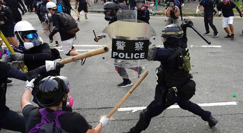 Police and demonstrators clash during a protest in Hong Kong, Saturday, Aug. 24, 2019. Chinese police said Saturday they released an employee at the British Consulate in Hong Kong as the city's pro-democracy protesters took to the streets again, this time