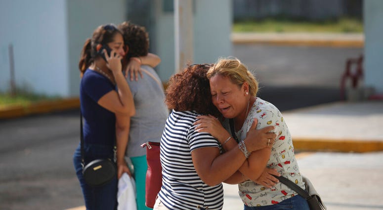 Relatives of one of the victims that died during an attack at a nightclub, cry outside the Veracruz state prosecutors office in Coatzacoalcos, Mexico, Wednesday, Aug. 28, 2019.