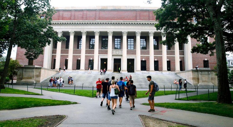 FILE - In this Aug. 13, 2019 file photo, students walk near the Widener Library in Harvard Yard at Harvard University in Cambridge, Mass. University and federal officials confirmed that incoming Harvard University student Ismail Ajjawi, 17, of Lebanon, wa