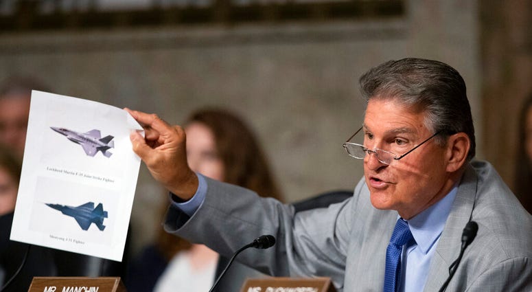 FILE - In this July 16, 2019, file photo, Senate Armed Services Committee member Sen. Joe Manchin, D-W.Va., shows an illustration of a Lockheed Martin F-35 Joint Strike Fighter jet, top, and China's Shenyang J-31 Stealth Fighter jet, bottom, as he questio