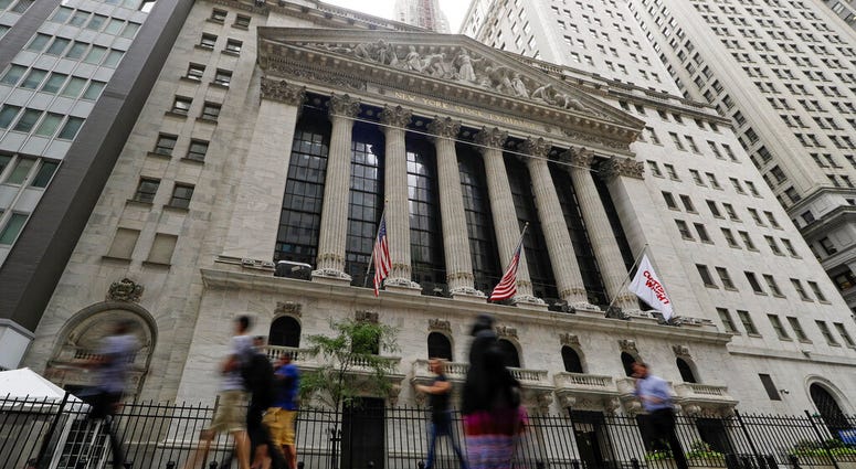 FILE - In this Aug. 23, 2019, file photo pedestrians pass the New York Stock Exchange in New York. Global stock markets were mostly lower Tuesday, Sept. 3, amid revived jitters over U.S.-Chinese trade tension, while wrangling by British lawmakers over whe