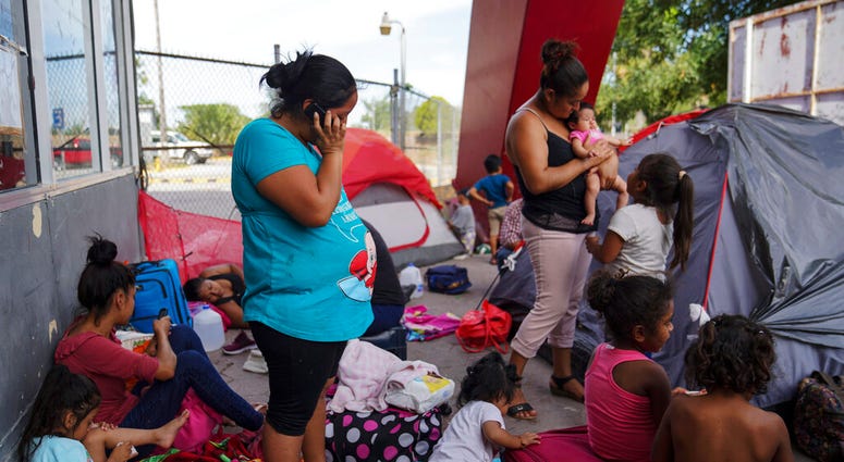 In this Aug. 30, 2019, photo, a group of Mexican asylum seekers wait near the Gateway International Bridge in Matamoros, Mexico. Pregnant women face special hazards in Mexico because places where migrants wait to enter the U.S. often don’t have access to