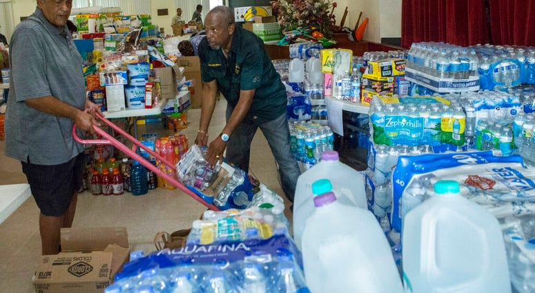 Ryan Smith, 60, left, and Hiram Williams, 71, stock an auditorium with goods slated to be sent to the Bahamas at Christ Episcopal Church in Miami, Tuesday, Sept. 3, 2019.