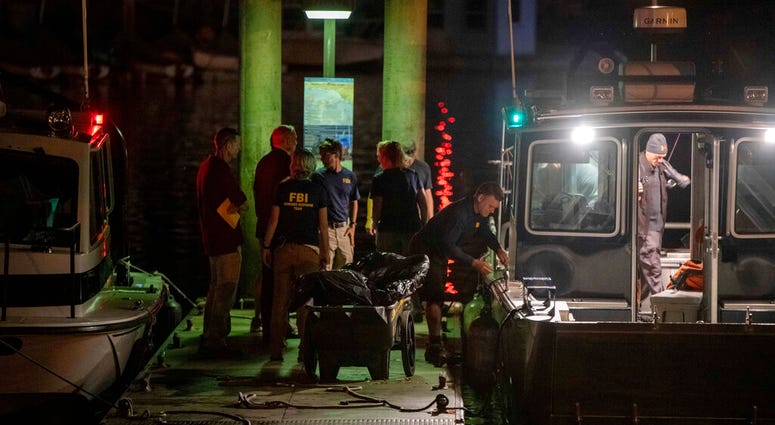 Authorities and FBI investigators cart away evidence taken from the scuba boat Conception in Santa Barbara Harbor at the end of their second day searching for the remaining divers still missing from the deadly pre-dawn fire on Tuesday, Sept. 3, 2019, in S