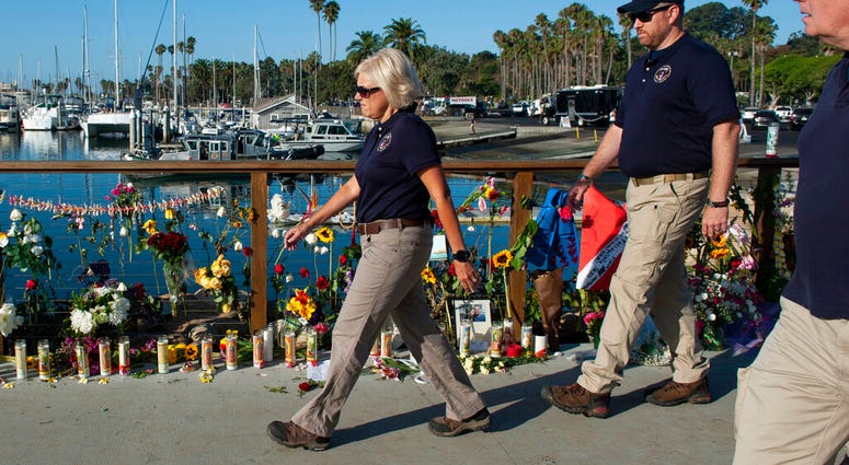 National Transportation Safety Board member Jennifer Homendy and her team walk past a memorial for the victims of a dive boat fire at Santa Barbara Harbor on Wednesday, Sept. 4, 2019 in Santa Barbara, Calif.