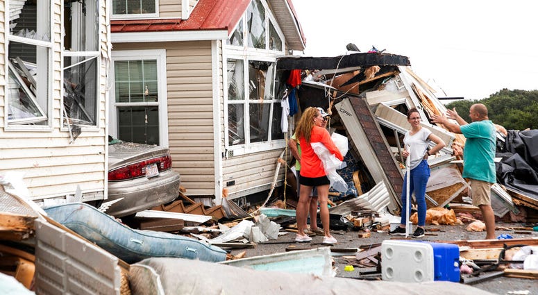 Residents of the Boardwalk RV Park discuss the path of a possible waterspout or tornado, generated by Hurricane Dorian, struck the area, Thursday, Sept. 5, 2019, in Emerald Isle, N.C. (Julia Wall/The News & Observer via AP)