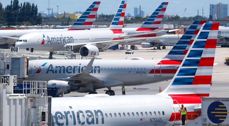 FILE - In this April 24, 2019, photo, American Airlines aircraft are shown parked at their gates at Miami International Airport in Miami.