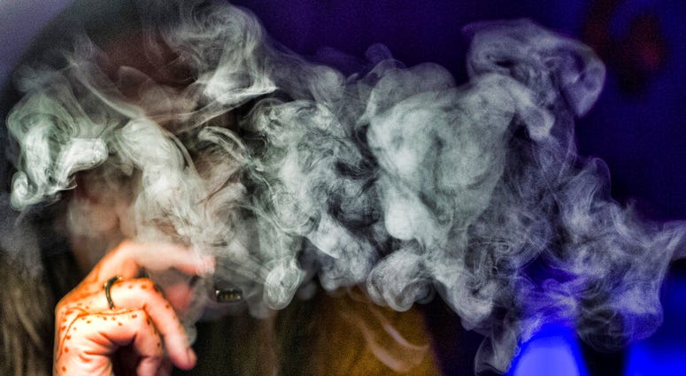 FILE - In this Saturday, Dec. 22, 2018 file photo, a woman takes a puff from a cannabis vape pen in Los Angeles. On Friday, Sept. 6, 2019, U.S. health officials are again urging people to stop vaping until they figure out why some are coming down with ser