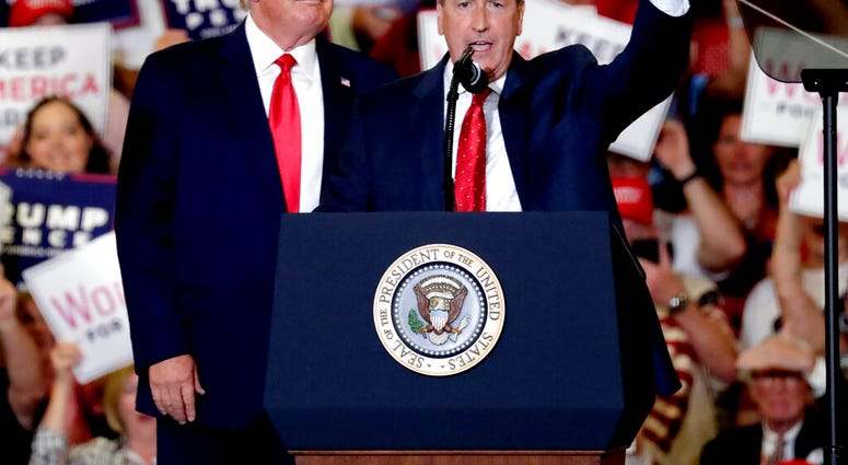 President Donald Trump, left, gives his support to Dan Bishop, right, a Republican running for the special North Carolina 9th District U.S. Congressional race as he speaks at a rally in Fayetteville, N.C., Monday, Sept. 9, 2019. (AP Photo/Chris Seward)