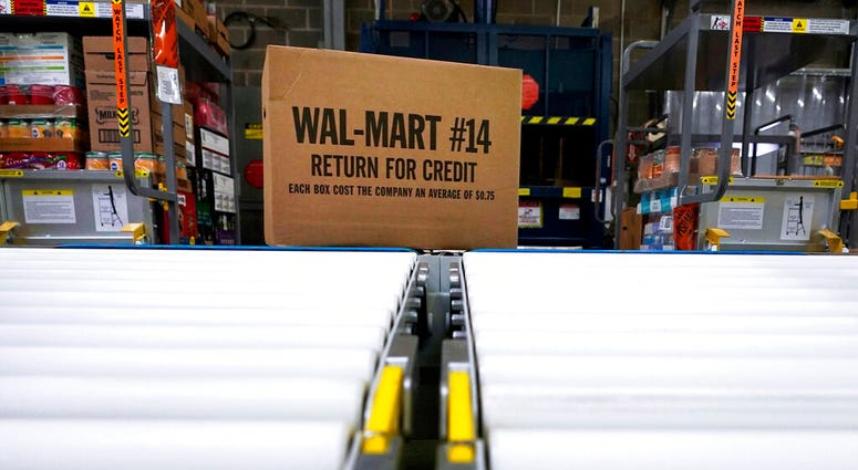 FILE - In this Nov. 9, 2018, file photo, a box of merchandise is unloaded from a truck and sent along a conveyor belt at a Walmart Supercenter in Houston. Walmart is rolling out an unlimited grocery delivery subscription service this fall for a $98 annual