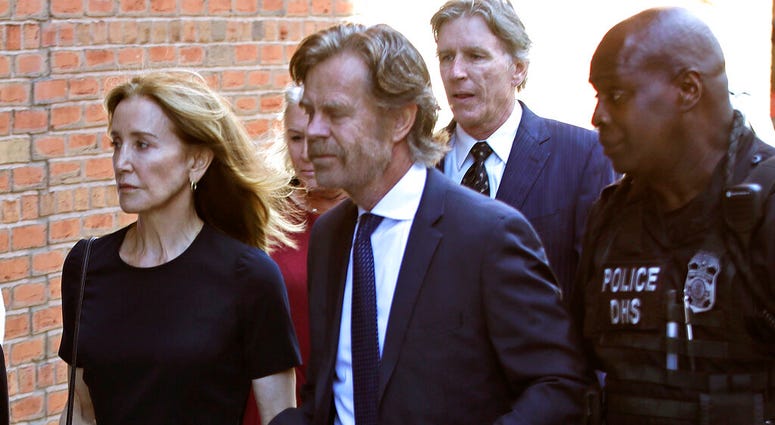 Felicity Huffman arrives at federal court with her husband William H. Macy and her brother Moore Huffman Jr., back, for sentencing in a nationwide college admissions bribery scandal, Friday, Sept. 13, 2019, in Boston. (AP Photo/Elise Amendola)