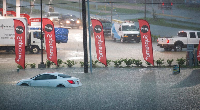 A flooded out car is stranded in high water off U.S. 59 as rain from Tropical Depression Imelda inundated the area on Thursday, Sept. 19, 2019, near Spendora, Texas.