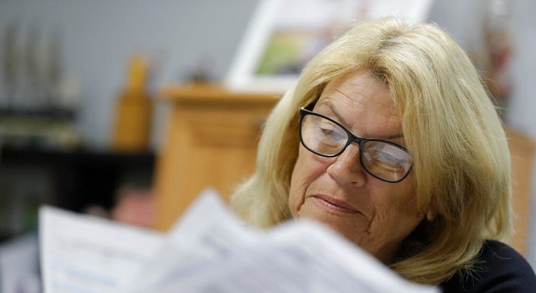 Linda Morris looks over her Medicare statements, Wednesday, Sept. 25, 2019, in Parker City, Ind. Federal law enforcement officials say they’ve taken down a nearly-$2 billion Medicare fraud scheme that exploited curiosity about genetic medicine by having s