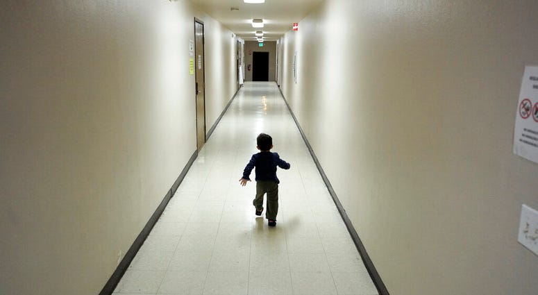 In this Dec. 11, 2018 file photo, an asylum-seeking boy from Central America runs down a hallway after arriving from an immigration detention center to a shelter in San Diego. (AP Photo/Gregory Bull, File)