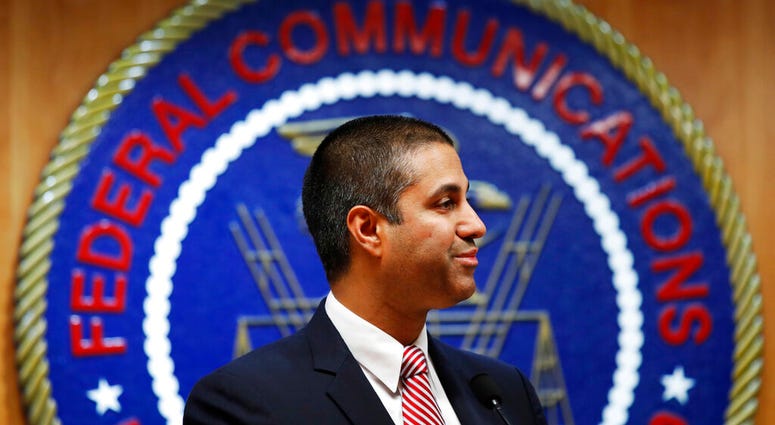 FILE - In this Dec. 14, 2017, file photo, after a meeting voting to end net neutrality, Federal Communications Commission (FCC) Chairman Ajit Pai smiles while listening to a question from a reporter in Washington.
