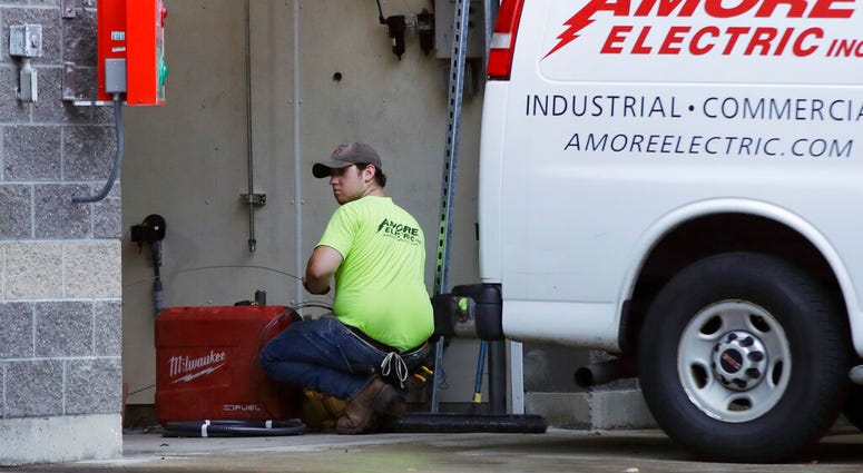 In this Wednesday, Oct. 2, 2019, photo, an electrician works at a car wash in North Andover, Mass. (AP Photo/Elise Amendola)