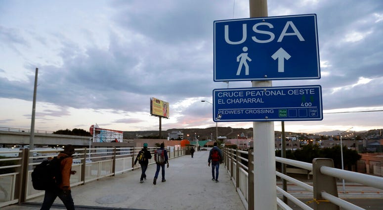 FILE - In this Sept. 27, 2016 file photo, Haitians make their way towards the border crossing in Tijuana, Mexico.