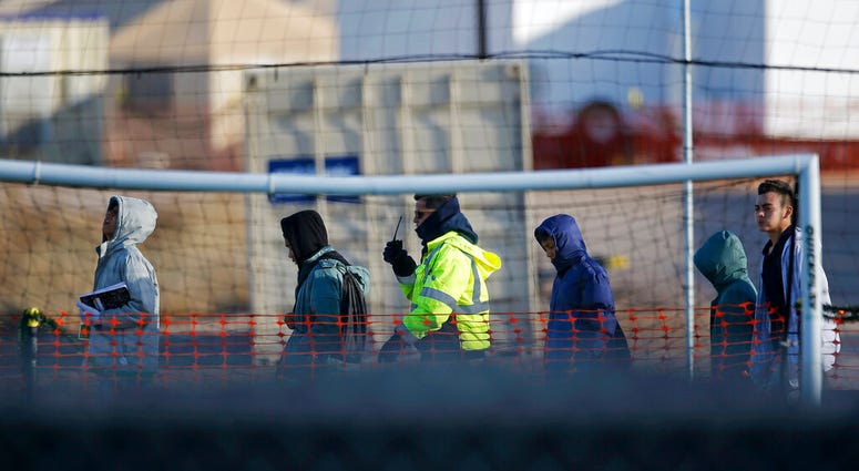 In this Dec. 13, 2018, file photo, teen migrants walk in line inside the Tornillo detention camp in Tornillo, Texas. (AP Photo/Andres Leighton, File)