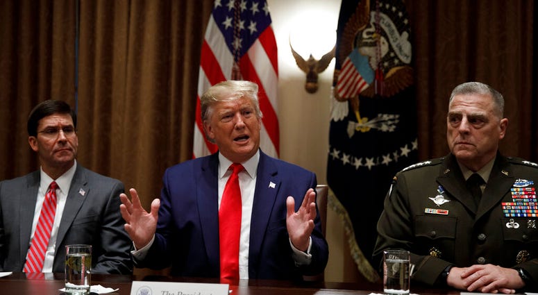President Donald Trump, joined by from left, Defense Secretary Mark Esper, and Chairman of the Joint Chiefs of Staff Gen. Mark Milley, at the White House in Washington, Monday, Oct. 7, 2019. (AP Photo/Carolyn Kaster)
