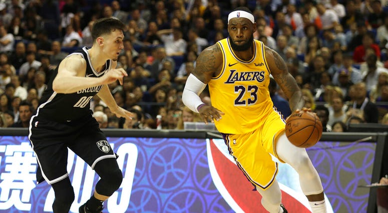 Los Angeles Lakers' Lebron James, right, drives against Brooklyn Nets' Rodions Kurucs, left, during their preseason NBA game in Shanghai, China, Thursday, Oct. 10, 2019. (AP Photo)
