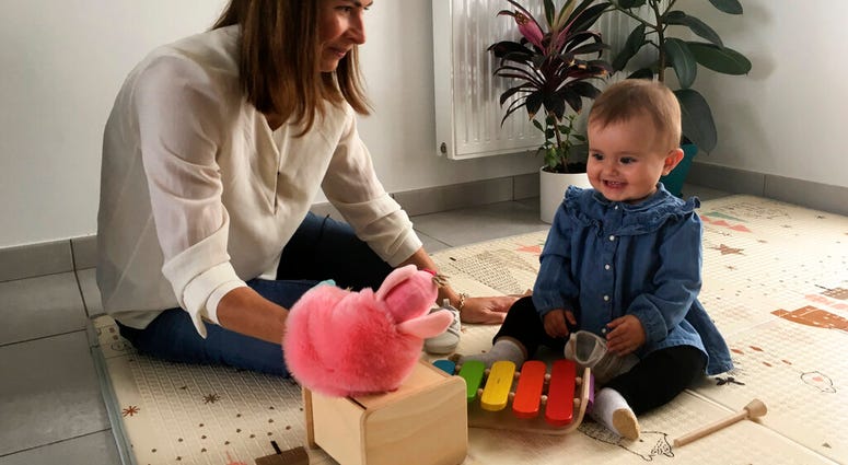 Sandrine Rudnicki, a 38 years old single woman smiles to her 10-month old daughter Emilia who was conceived through in-vitro fertilization, Monday Oct.14, 2019 in Saint-Pryve-Saint-Mesmin, near Orleans, France.(AP Photo/Catherine Gaschka)