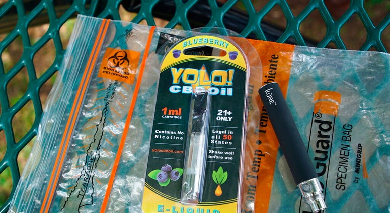 FILE - In this May 8, 2019, file photo, a Yolo! brand CBD oil vape cartridge sits alongside a vape pen on a biohazard bag on a table at a park in Ninety Six, S.C. (AP Photo/Allen G. Breed, File) FILE - In this May 8, 2019, file photo, a Yolo! brand CBD oil vape cartridge sits alongside a vape pen on a biohazard bag on a table at a park in Ninety Six, S.C. (AP Photo/Allen G. Breed, File)