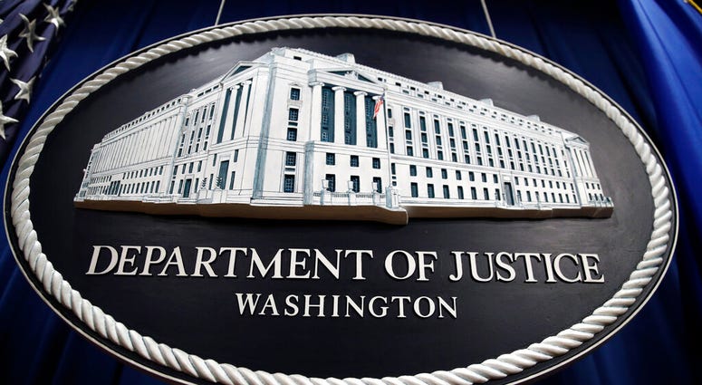 In this Thursday, April 18, 2019, file photo, a sign for the Department of Justice hangs in the press briefing room at the Justice Department, in Washington. (AP Photo/Patrick Semansky, File)