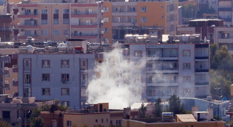 Smoke billows from targets in Ras al-Ayn, Syria, caused by shelling by Turkish forces, Friday, Oct. 18, 2019. (AP Photo/Lefteris Pitarakis)