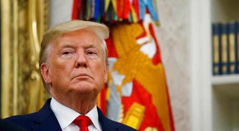 President Donald Trump stands during a Presidential Medal of Freedom ceremony for auto racing great Roger Penske in the Oval Office of the White House, Thursday, Oct. 24, 2019, in Washington. (AP Photo/Alex Brandon)