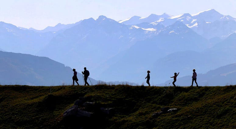 People make their way from the 'Kitzbuehler Horn' mountain (1,996 meters) at the alps near Kitzbuehl, Austria, Sunday, Oct. 27, 2019.(AP Photo/Matthias Schrader)