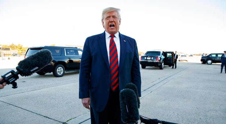 President Donald Trump talks to reporters before boarding Air Force One for a trip to Chicago. (AP Photo/Evan Vucci)