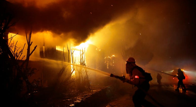 Firefighters try to hose down flames as homes burn in the Getty fire area along Tigertail Road, Monday, Oct. 28, 2019, in Los Angeles. (AP Photo/Marcio Jose Sanchez) Firefighters try to hose down flames as homes burn in the Getty fire area along Tigertail Road, Monday, Oct. 28, 2019, in Los Angeles. (AP Photo/Marcio Jose Sanchez)