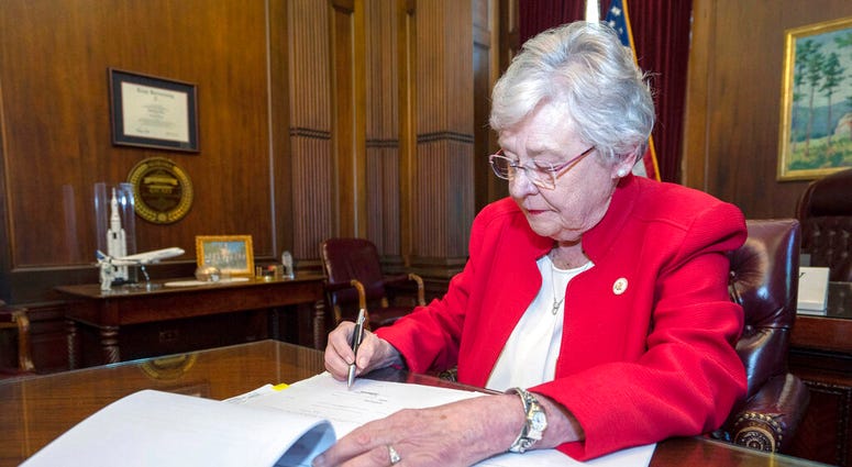 FILE-In this Wednesday, May 15, 2019 file photo released by the state shows Alabama Gov. Kay Ivey signing a bill that virtually outlaws abortion in the state, in Montgomery, Ala.